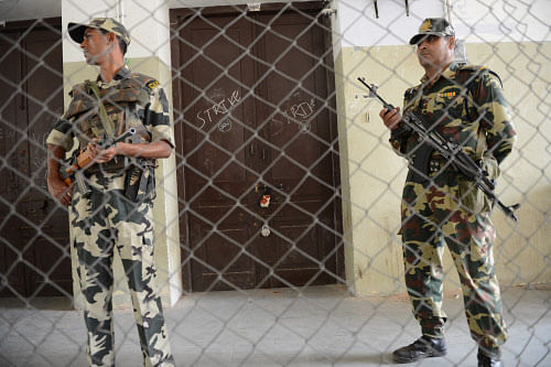 Paramilitary soldiers keep watch outside a strong room where voting equipment are being kept in a hall, where the counting of votes will be held following the recent Gujarat state assembly polls, in Ahmedabad on December 19, 2012. The results of the Gujarat Assembly polls which were held in two phases on December 13 and 17 are expected to be announced on December 20. AFP PHOTO / Sam PANTHAKY