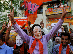 Indian supporters of Bharatiya Janata Party (BJP) wear masks of Gujarat chief minister Narendra Modi as they celebrate to early reports that their party is leading in the Gujarat assembly elections in Ahmadabad, India, Thursday, Dec. 20, 2012. The votes are currently being counted with the final results expected later in the day. AP