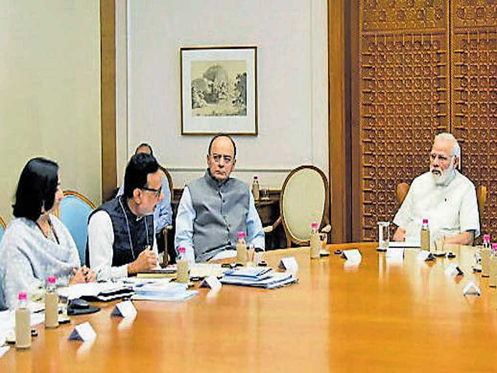 Prime Minister Narendra Modi reviews the status of GST in New Delhi on Monday. Finance Minister Arun Jaitley and Revenue Secretary Hasmukh Adhia are also seen. PTI Photo