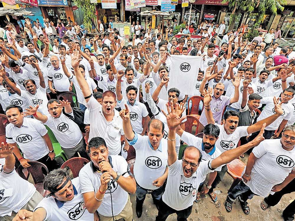 Cloth merchants and workers shout slogans during a protest against the implementation of GST in Kolkata on Wednesday. REUTERS