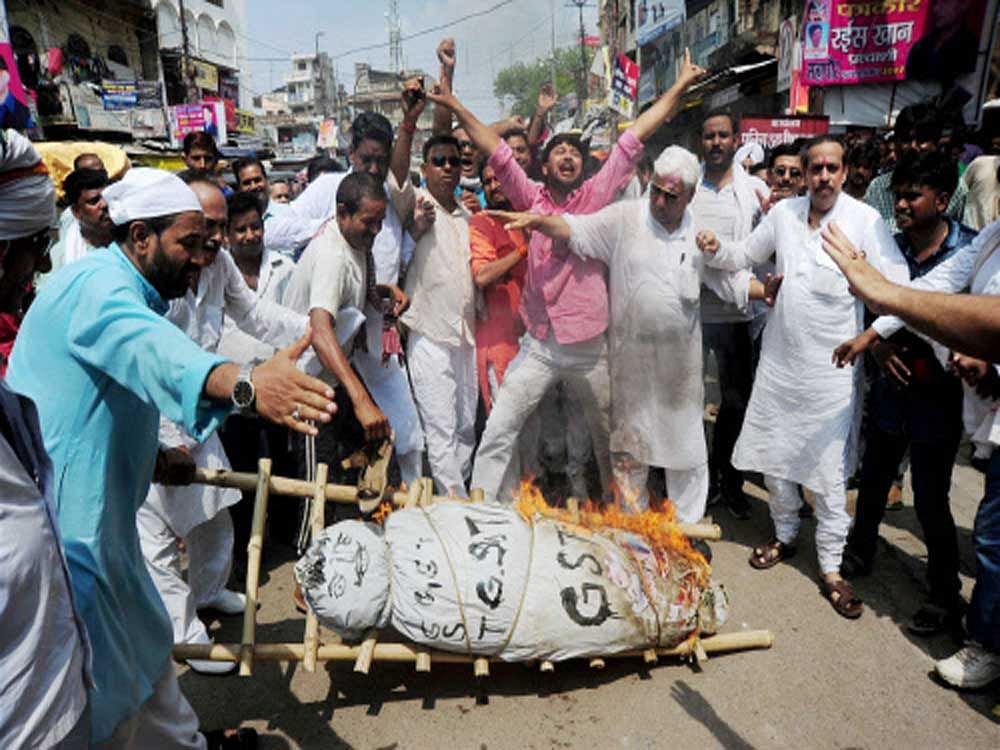 Traders raise slogans and burn an effigy of GST (Goods service tax) during a protest in Allahabad on Friday. Traders from accross the country called for a shut down. PTI Photo