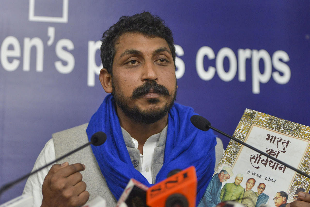 Bhim Army Chief Chandrasekhar Azad holds a copy of the Indian Constitution at a press conference in New Delhi. PTI