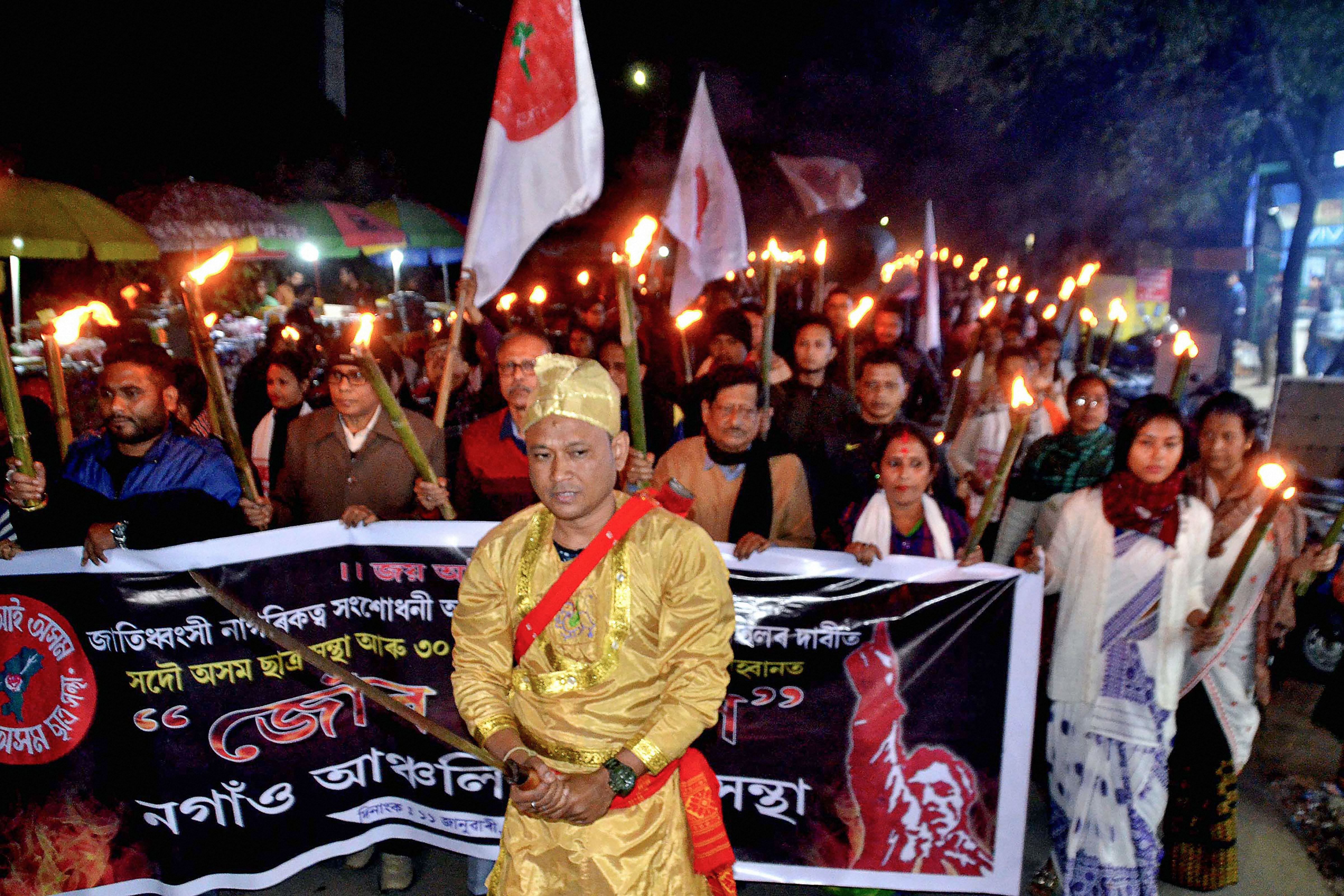  All Assam Students' Union (AASU) members along with senior citizens participate in a torch rally during a protest against Citizenship Law (CAA) in Nagaon.(PTI Photo)