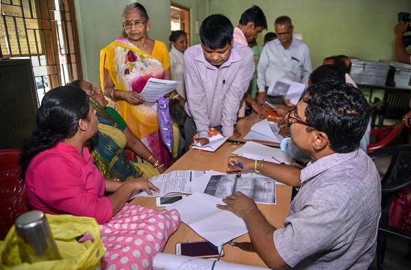 People verify the National Register of Citizens (NRC) forms to file claims and objections at an NRC centre, in Guwahati. (PTI Photo)