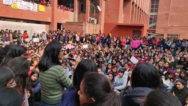 Delhi Commission For Women chief Swati Maliwal (in green sweater) addresses students during a protest, against the alleged molestation of students by a group of men who had gatecrashed a cultural festival, at Gargi College, in New Delhi. (PTI Photo)