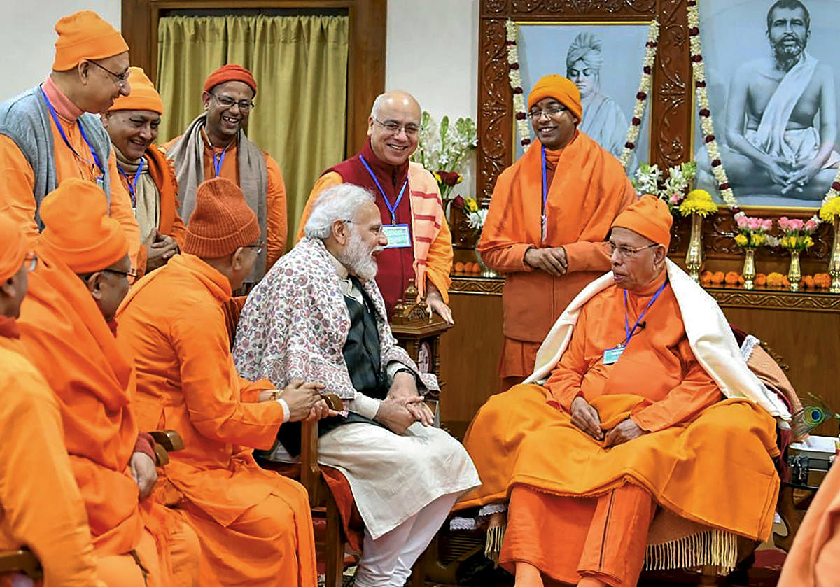 Prime Minister Narendra Modi with monks at Belur Math in Howrah district. Modi on Sunday paid tribute to Swami Vivekananda on his birth anniversary. PTI