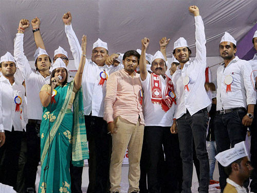 Leaders from Patel or Patidar community raise their hands attending a reservation rally led by Bardik Patel (center) at Bapunagar in Ahmedabad. PTI file photo