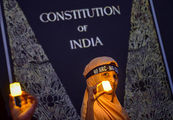 A Muslim girl holds LED-bulb light during a protest against CAA, NRC and NPR, in Bengaluru, Friday, Jan. 24, 2020. (PTI Photo)