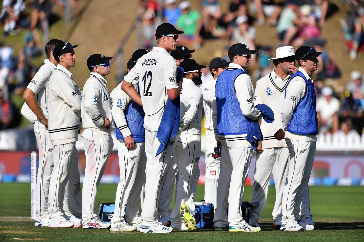 New Zealand players watch the screen as a DRS is review on India's Mayank Agarwal during day three of the first Test cricket match between New Zealand and India at the Basin Reserve. (AFP Photo)