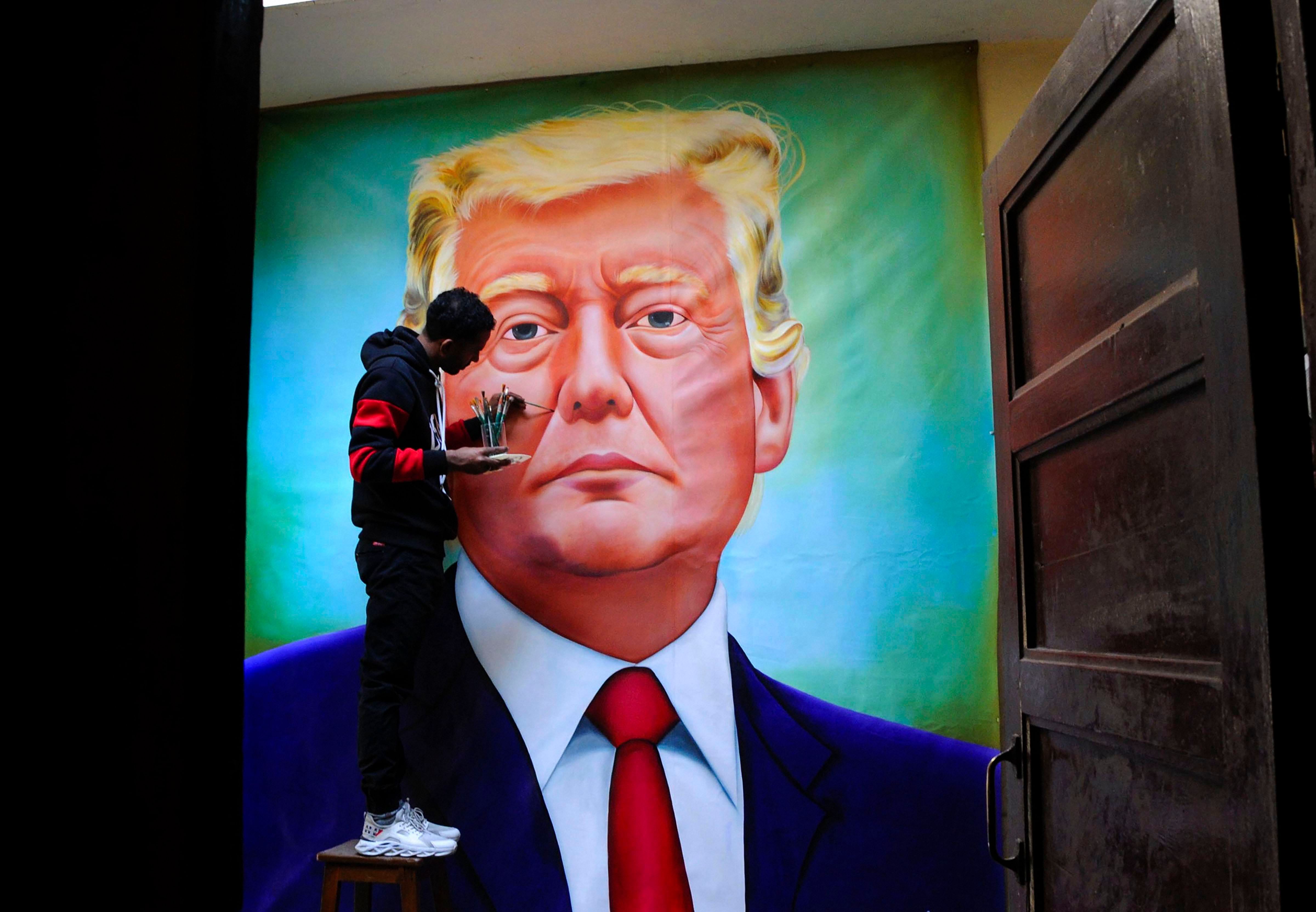 Artist Jagjot Singh Rubal gives final touches to a painting of US President Donald Trump. (PTI Photo)