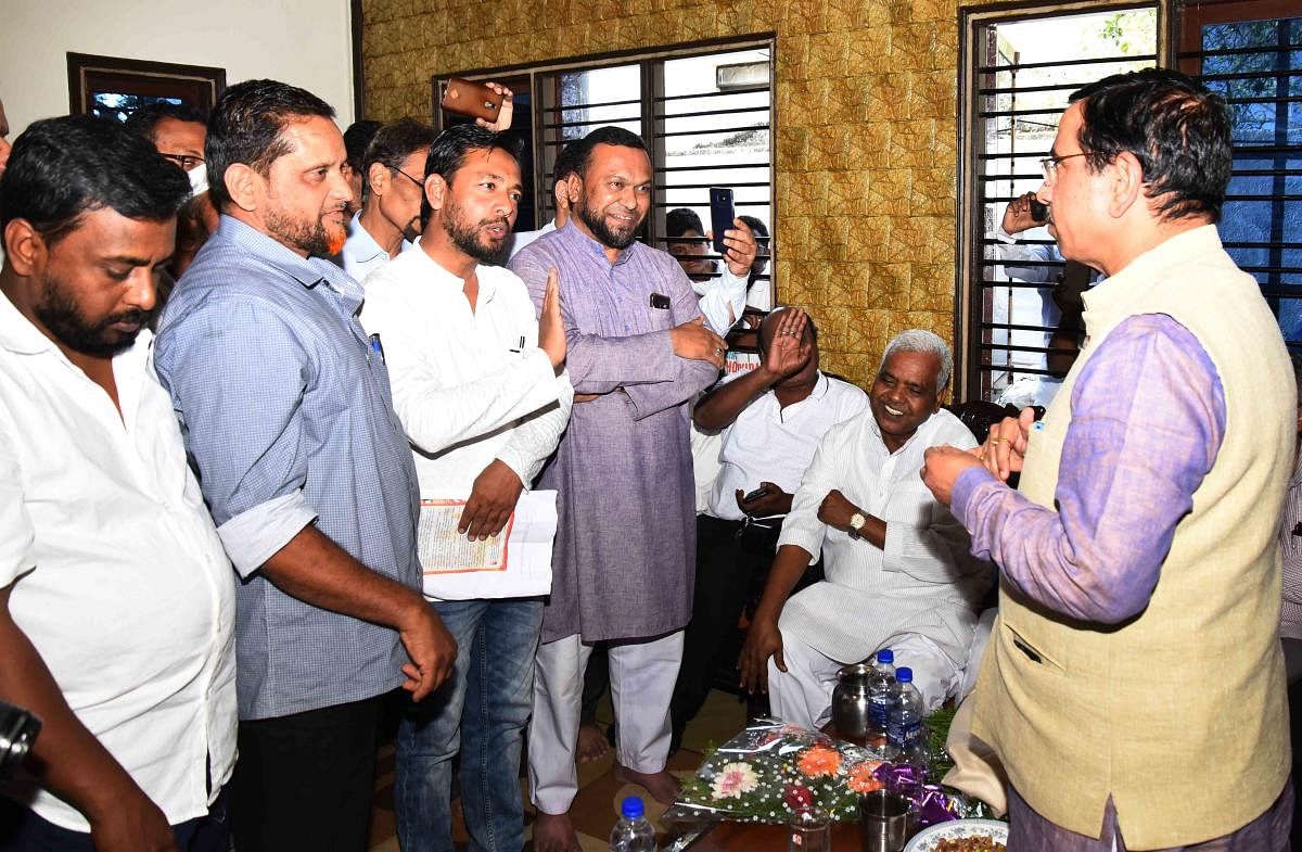 Union Parliamentary Affairs Minister prahlad Joshi speaks to Muslims during people outreach campaign by the BJP on CAA at the residence of R M Dargad at Shivgiri in Dharwad on Sunday. DH Photo