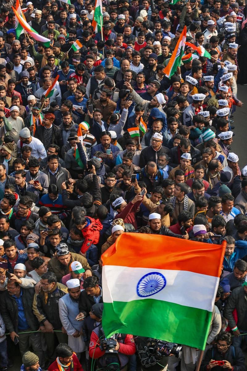 Anti-CAA protestors waves tri-colours as they celebrate the 71st Republic Day at Shaheen Bagh in New Delhi, Sunday, Jan. 26, 2020. Protests have been going on at Shaheen Bagh for over a month against the Citizenship Amendment Act (CAA) and proposed Nation