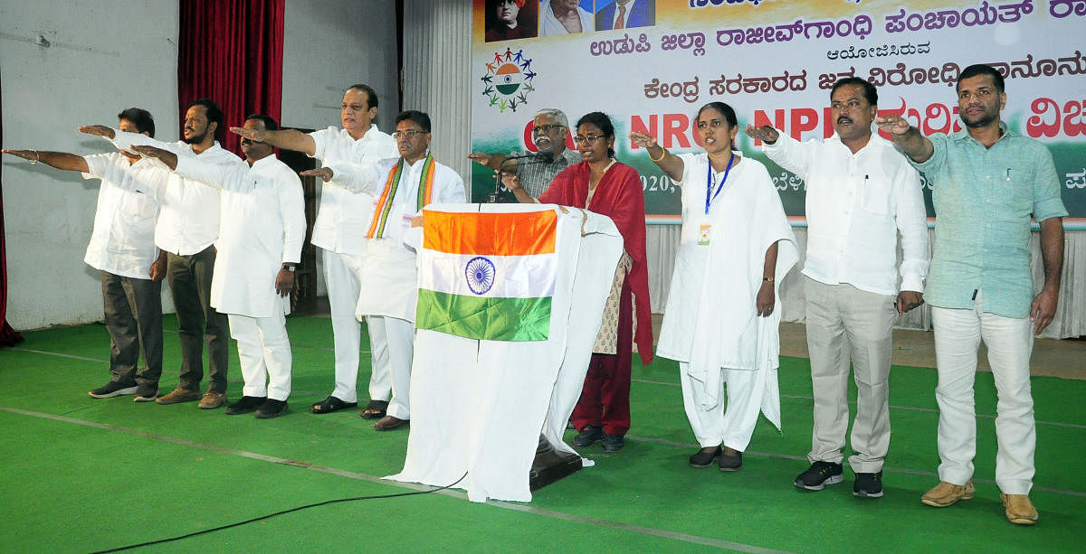 Speakers recite the Preamble to the Constitution and take oath at a programme at Town Hall in Ajjarkadu in Udupi on Thursday.