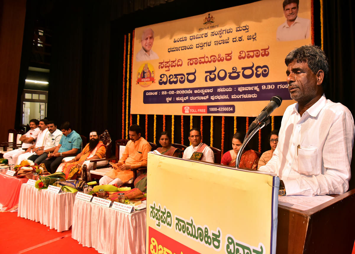 Minister for Fisheries, Port and Inland Transport, and Muzrai Kota Srinivas Poojary speaks during a seminar on ‘Sapthapadi Mass Marriage’, organised by Hindu Religious Institutions and Charitable Endowment department, at Kudmal Ranga Rao Town Hall in Mangaluru on Sunday. DH Photo