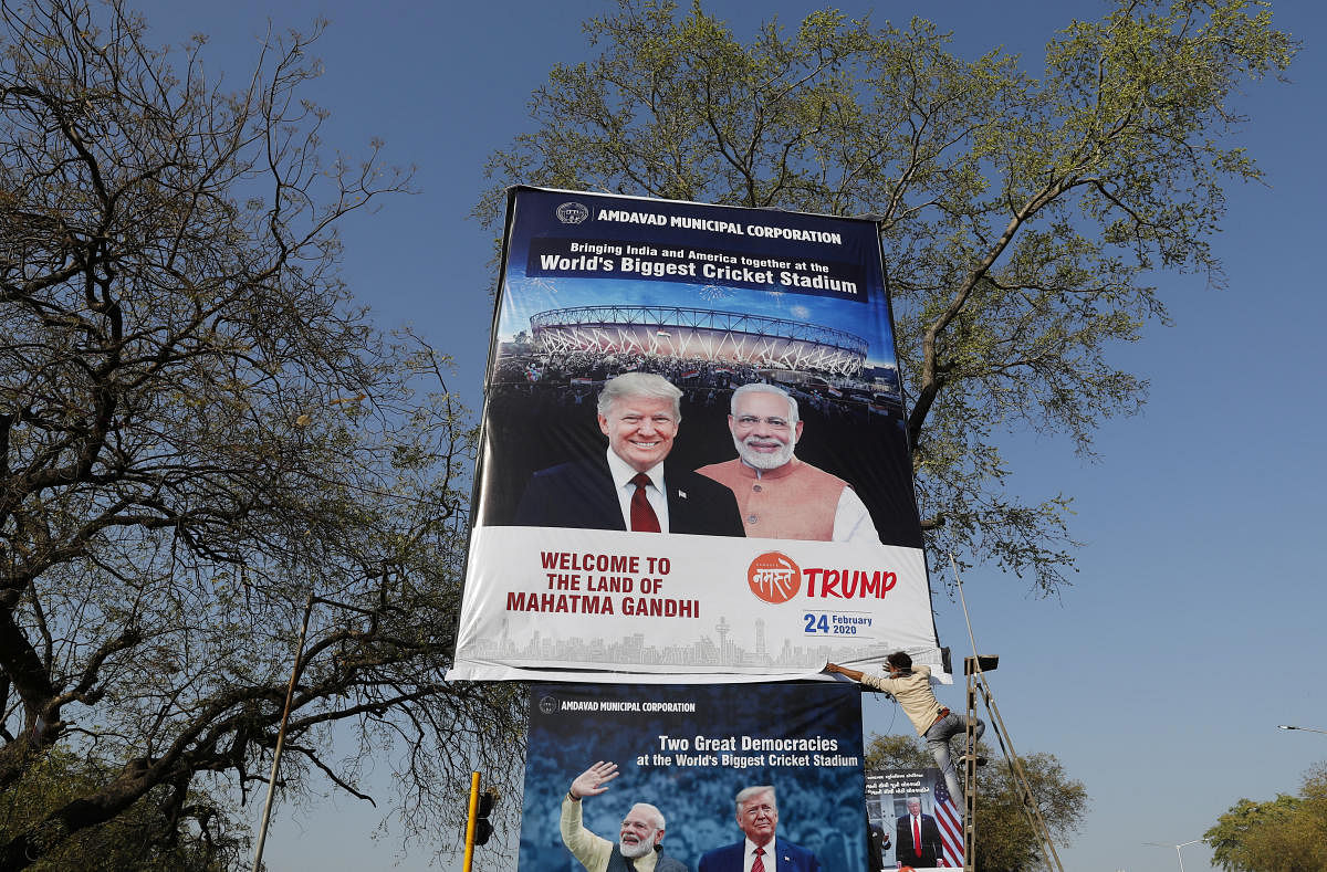 A worker installs a hoarding with the images of India's Prime Minister Narendra Modi and U.S. President Donald Trump along a road ahead of Trump's visit, in Ahmedabad, India, February 22, 2020. (Reuters Photo)