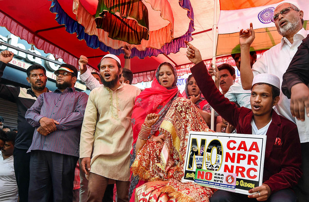 A newly-wed couple along with others raise slogans during an anti-CAA rally, at Washermanpet area of Chennai. (PTI Photo)
