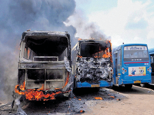 Protestors set ablaze buses during clashes with the police in Surat on Wednesday. PTI