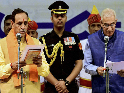 Gujarat's new Chief Minister Vijay Rupani is administered oath by Governor O P Kohli at the swearing-in ceremony in Gandhinagar on Sunday. PTI