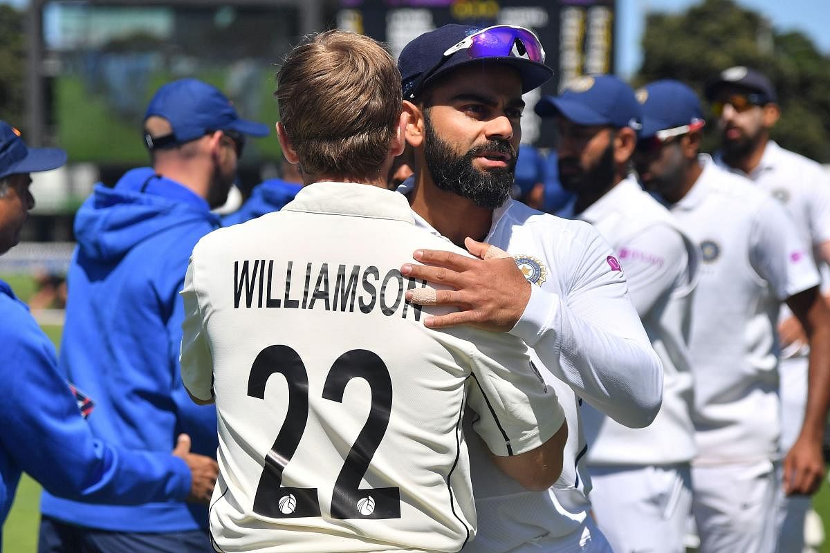 New Zealand's captain Kane Williamson (L) hugs India's captain Virat Kohli after New Zealand's win during day four of the first Test cricket match between New Zealand and India at the Basin Reserve in Wellington on February 24, 2020. (Photo by Marty MELVILLE / AFP)