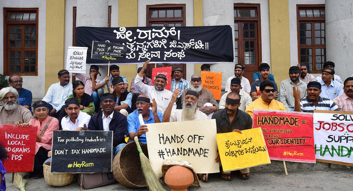 Members of the Grama Seva Sangh, led by theatre personality Prasanna, stage a protest at Town Hall Circle on Sunday, demanding zero GST on all handmade goods. DH PHOTO/ANAND Bakshi