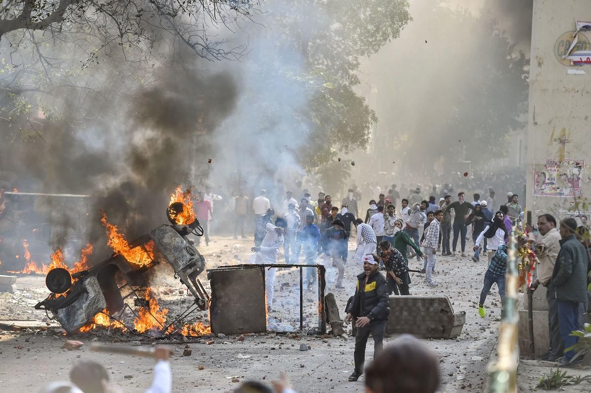 Vehicles set ablaze as protestors throw brick-bats during clashes between a group of anti-CAA protestors and supporters of the new citizenship act, at Jafrabad in north-east Delhi, Monday, Feb. 24, 2020. (PTI Photo)