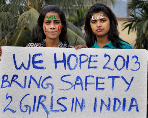 Two girls wish safety for girls as they prepare to welcome the New Year 2013 in Guwahati on Monday