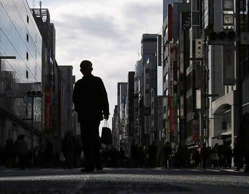 A man holding a shopping bag walks on a street at Tokyo's Ginza shopping district November 16, 2014. Reuters