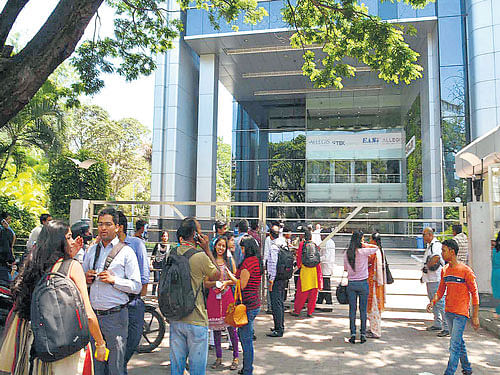 No entry: Employees of various companies wait outside the Classic Reality Mall on Bannerghatta Road on Thursday after it was sealed for not paying property tax. DH Photo