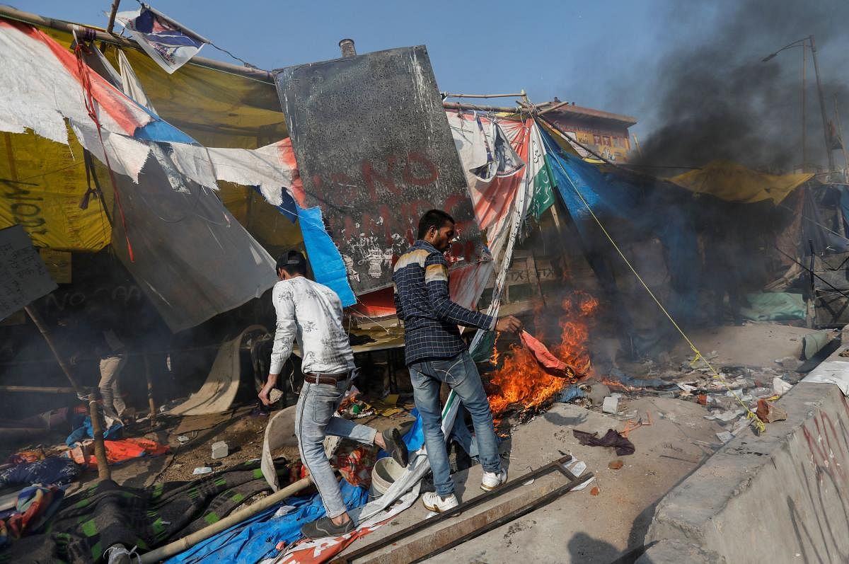 People supporting a new citizenship law destroy the protest site used by those opposing it, in New Delhi. Credit: Reuters Photo