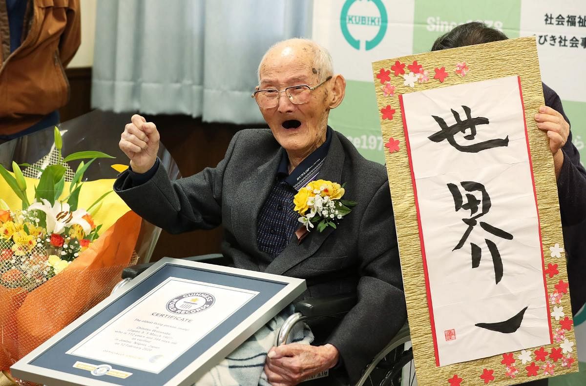Chitetsu Watanabe poses next to calligraphy reading in Japanese 'World Number One' after he was awarded as the world's oldest living male in Joetsu. (AFP file photo)