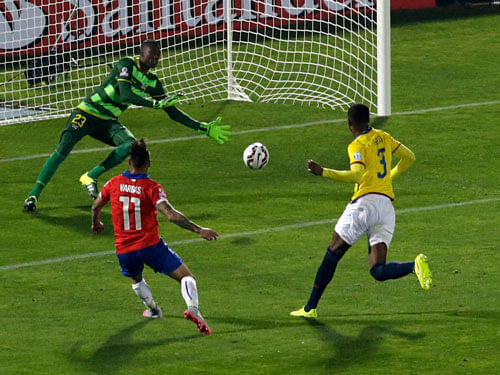Chile's Eduardo Vargas (11) scores against Ecuador's goalie Alexander Dominguez during the opening match of the Copa America 2015 soccer tournament in the National Stadium in Santiago, Chile.Reuters Photo.