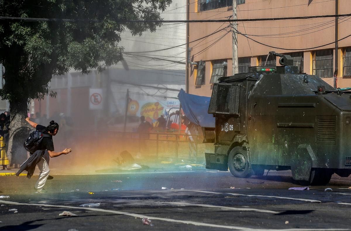Fresh clashes broke out in Chile's capital Santiago on Sunday after two people died when a supermarket was torched overnight as violent protests sparked by anger over economic conditions and social inequality raged into a third day. (Photo by JAVIER TORRES / AFP)