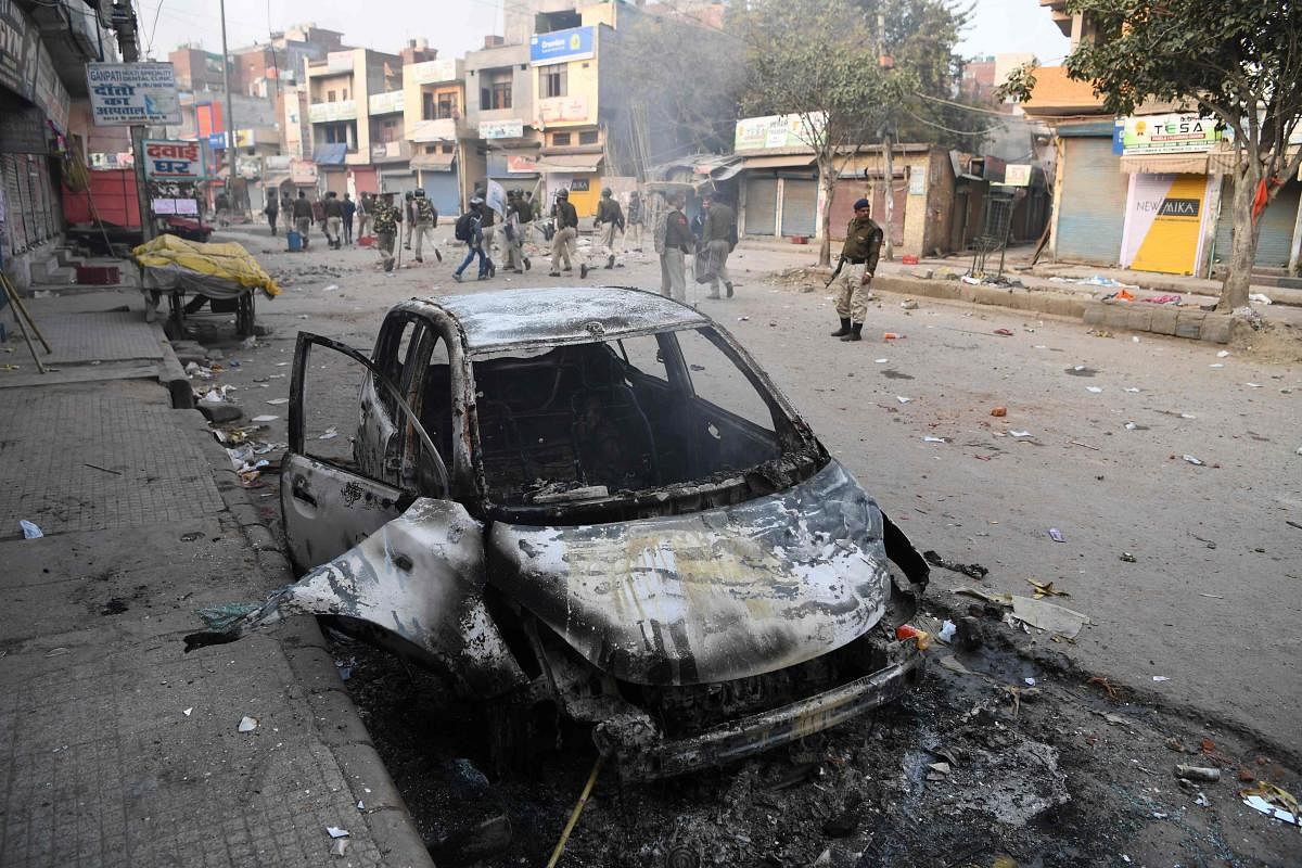 A burnt vehicle is pictured following clashes between supporters and opponents of a new citizenship law, at Bhajanpura area of New Delhi on February 24, 2020. Credit: AFP Photo