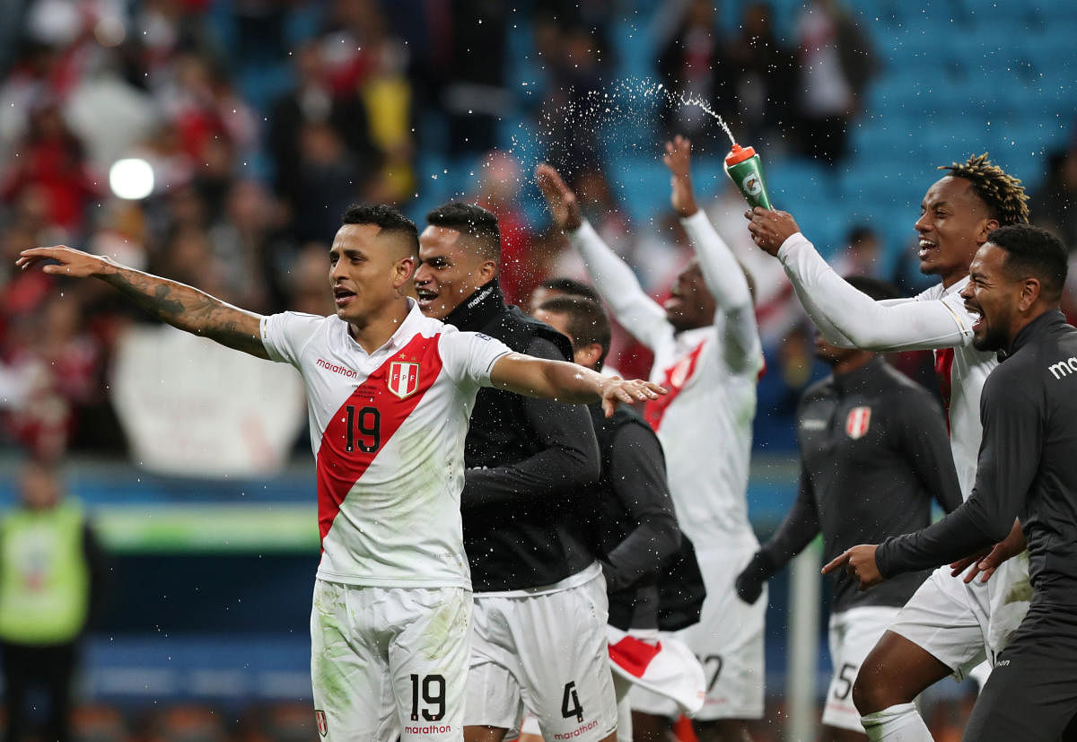 Peru's Andre Carillo, Victor Yotun and team mates celebrate after the match. (Reuters Photo)