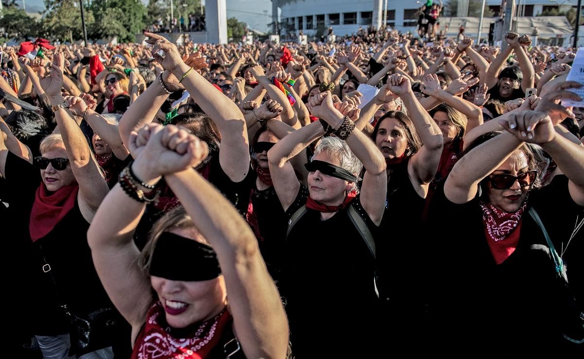 Feminist activists take part in a choreographed performance against gender violence, outside the national stadium. Photo by AFP.