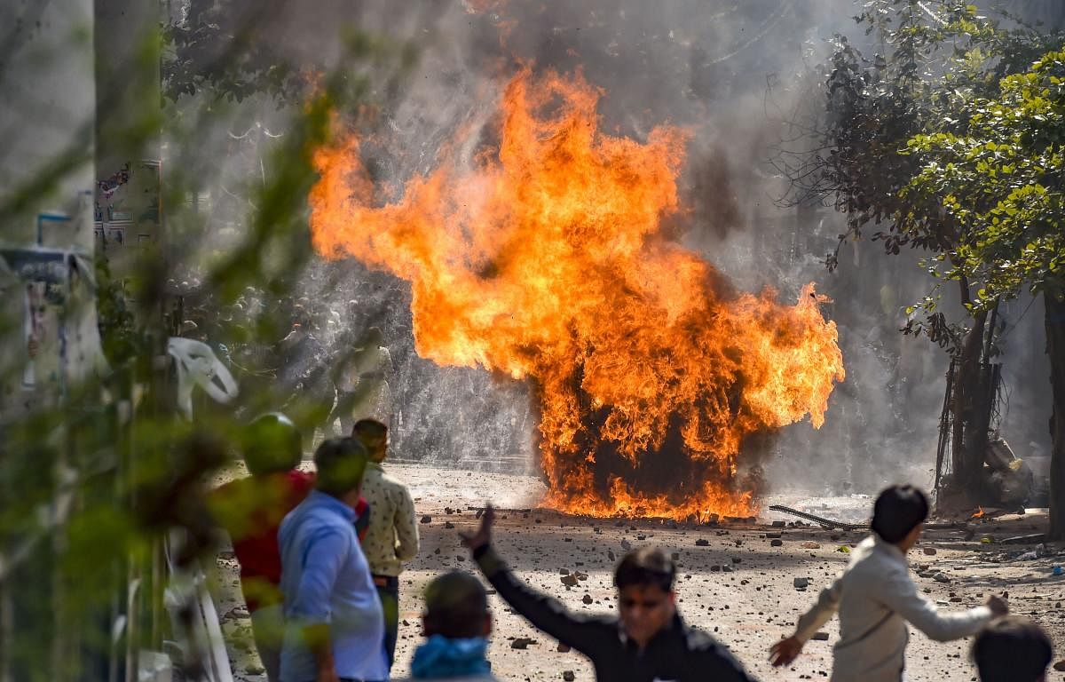 Vehicles set ablaze as protestors throw brick-bats during clashes between a group of anti-CAA protestors and supporters of the new citizenship act, at Jafrabad in north-east Delhi, Monday, Feb. 24, 2020. (PTI Photo)