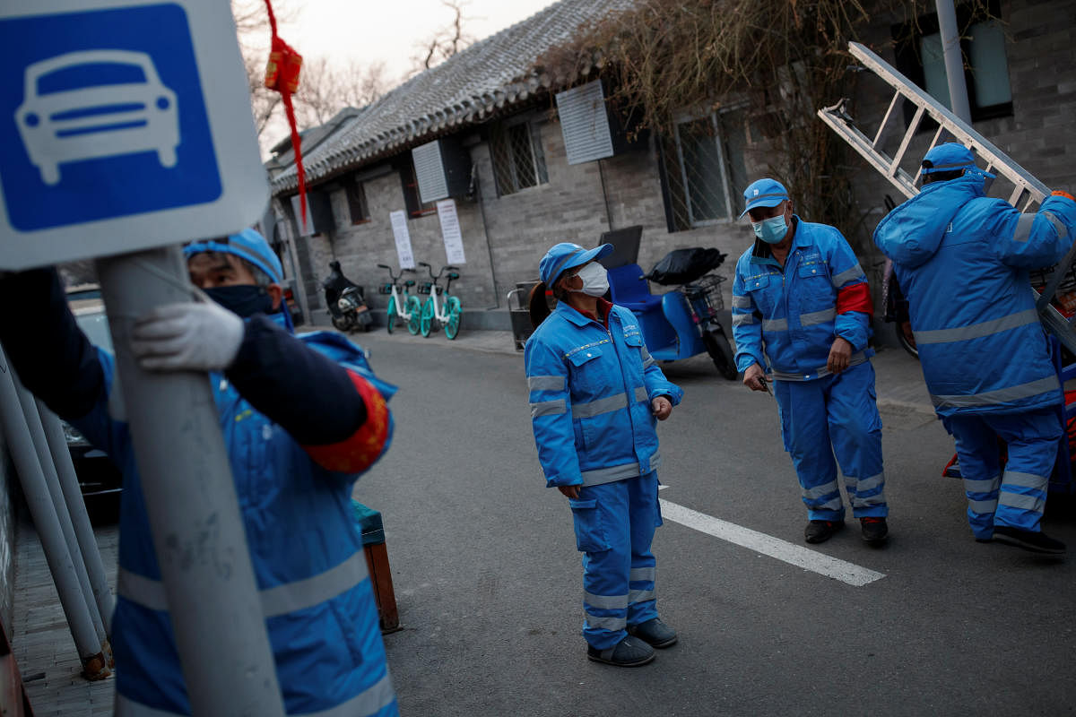 Workers wear face masks as they remove Chinese New Year decorations in a hutong neighbourhood in Beijing as the country is hit by an outbreak of the novel coronavirus, China, February 25, 2020. (Reuters Photo)
