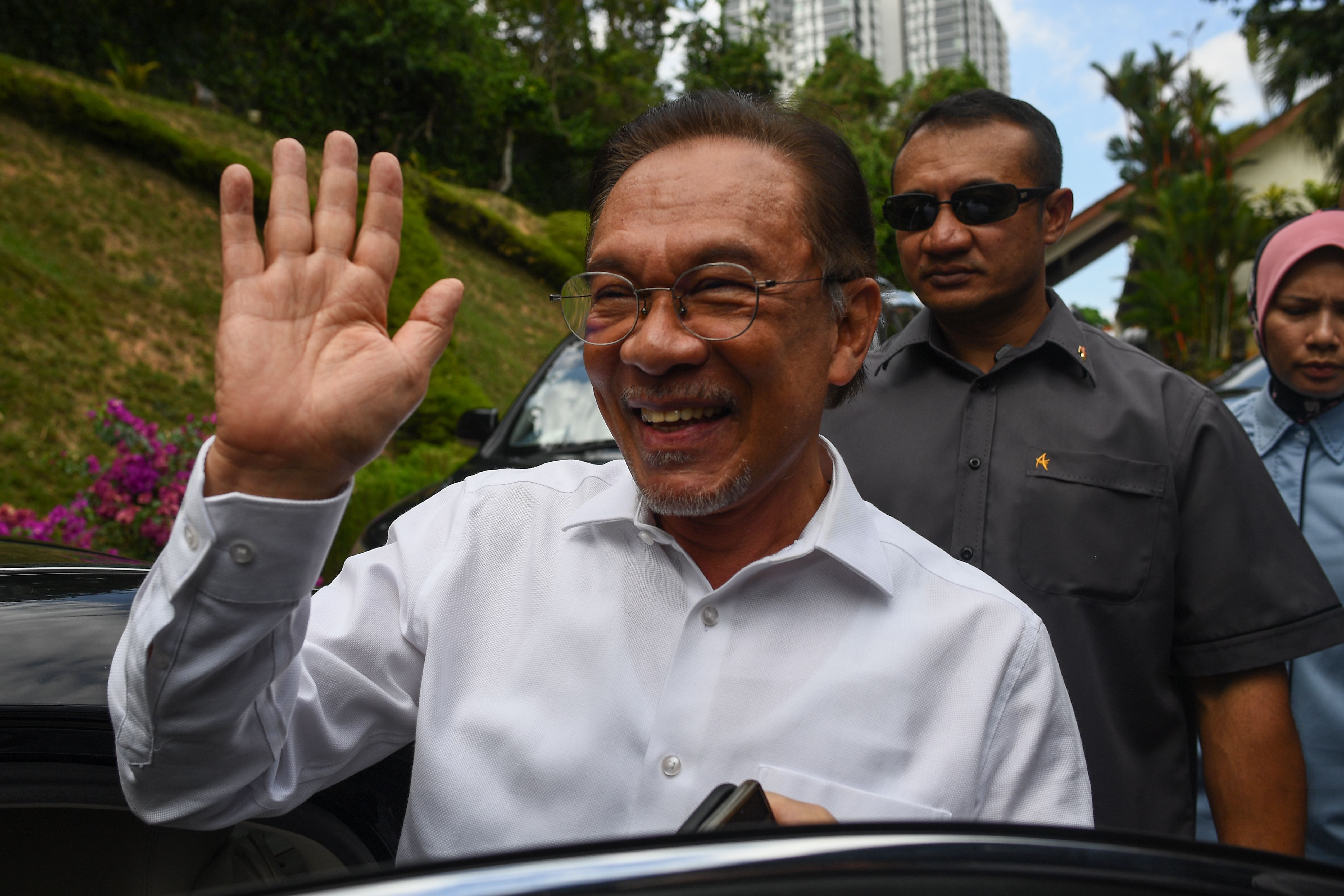 Politician Anwar Ibrahim waves as he leaves his home in Kuala Lumpur. (AFP Photo)