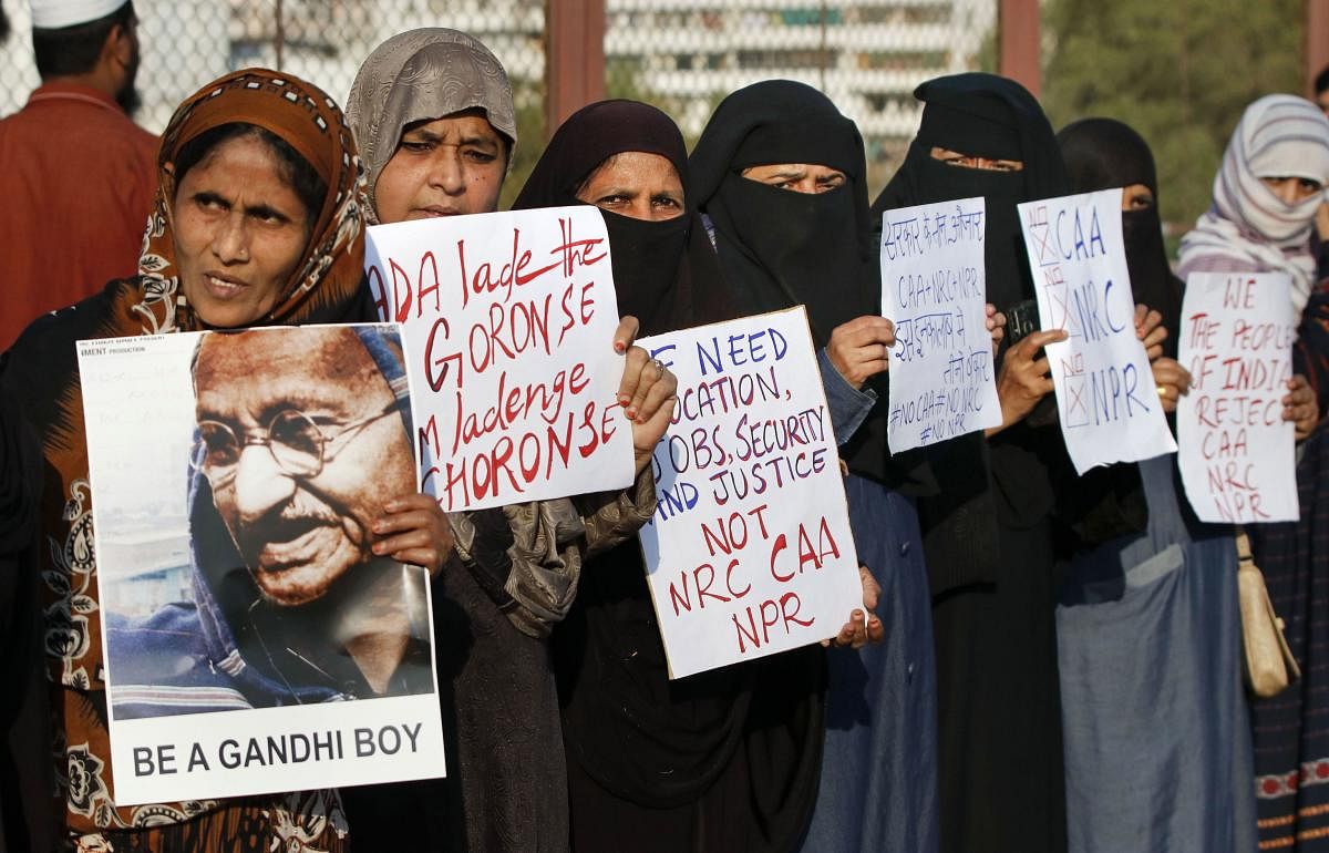  Women display placards during a protest against the new Citizenship Act, in Ahmedabad (PTI Photo)