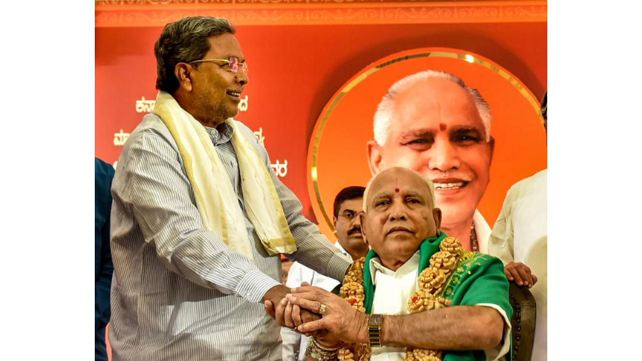 Congress leader and leader of opposition in the Karnataka assembly Siddaramaiah greets Chief Minister B S Yediyurappa on his birthday (PTI Photo)