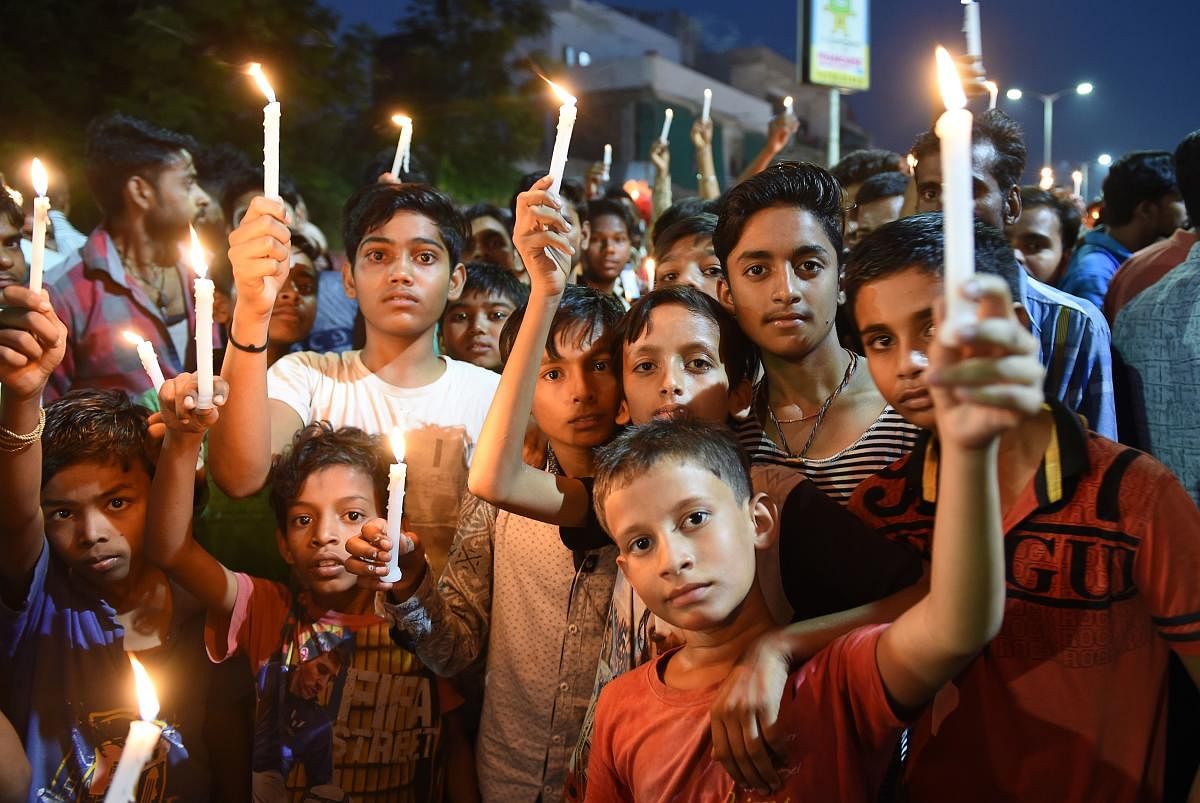 Indian citizens participate in a candle-light vigil in support of a 14-month-old girl who was raped in the Himmatnagar region of Gujarat in Ahmedabad. (AFP photo)