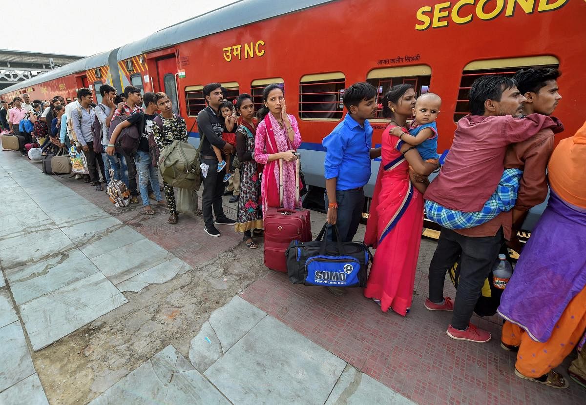 Migrant workers wait to board a train out of Gujarat in view of protests and violence breaking out over the alleged rape of a 14-month-old girl, in Ahmedabad. PTI