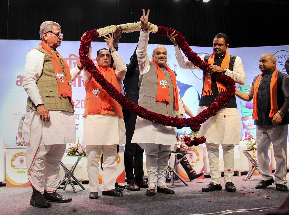 BJP president Amit Shah and Gujarat Chief Minister Vijay Rupani being garlanded by party leaders during the launch of 'My Family, BJP Family' campaign, in Ahmedabad. PTI