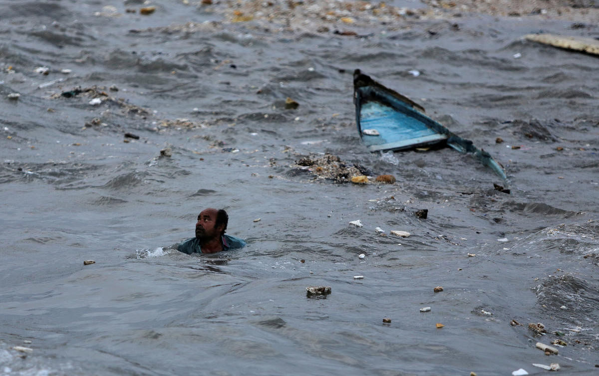 A fisherman swims to shore after his boat capsized due to high waves ahead of the expected landfall of Cyclone Vayu at Veraval, India, June 12, 2019. (Photo: REUTERS)