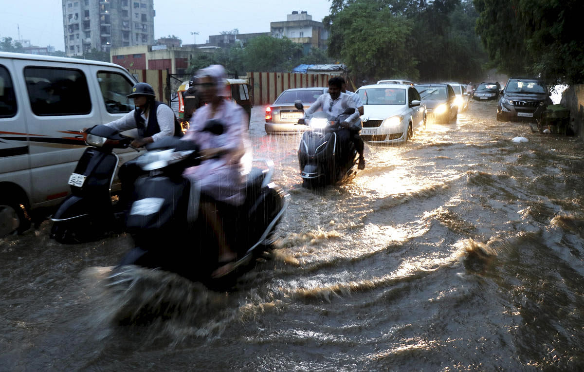 Vehicles move slowly on a waterlogged street during heavy rain in Ahmadabad on Wednesday July 31, 2019.( PTI Photo)