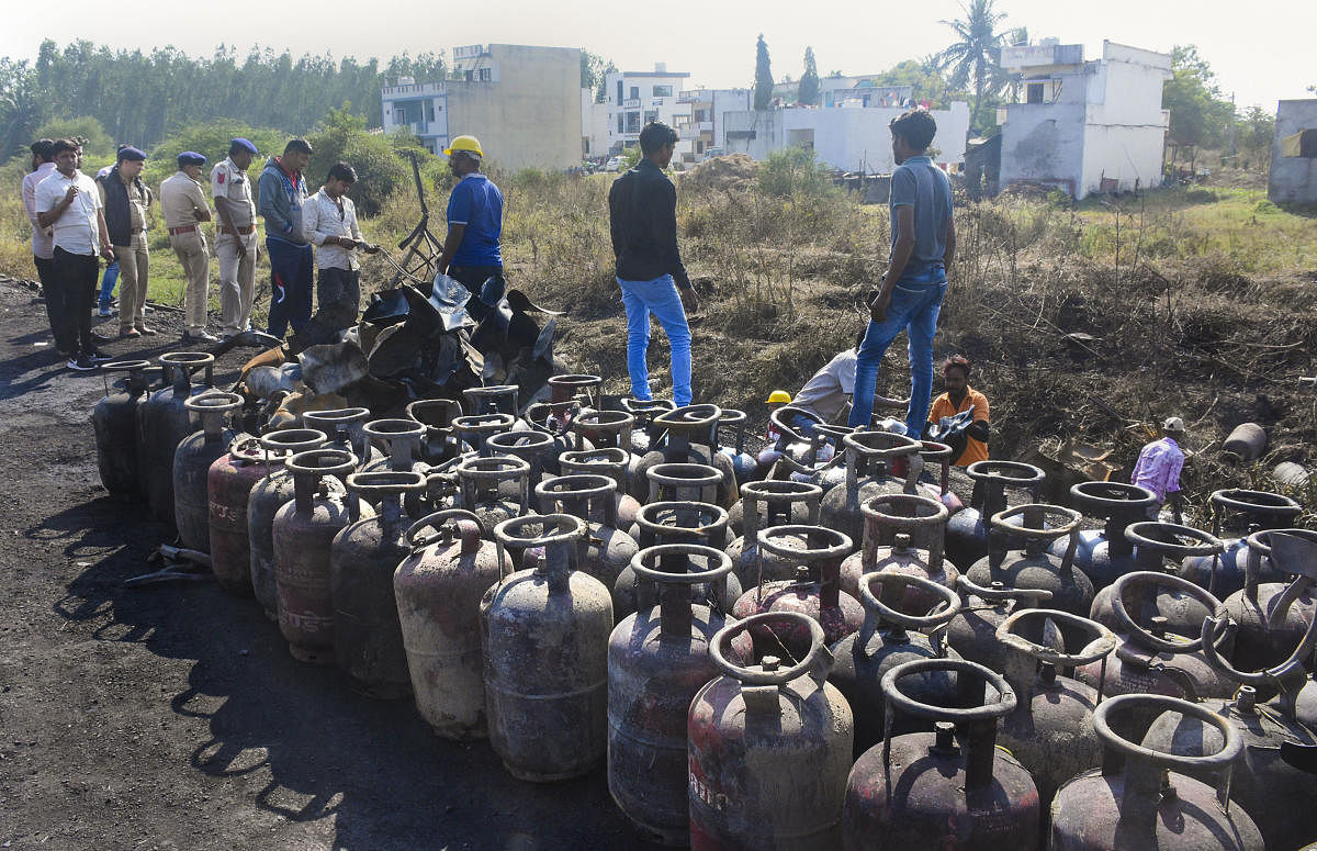 Locals and police try to recover LPG cylinders from a ditch after a blast in a truck carrying cylinders, at Masma Villages in Olpad in Surat district, Thursday, Jan. 9, 2020. (PTI Photo)