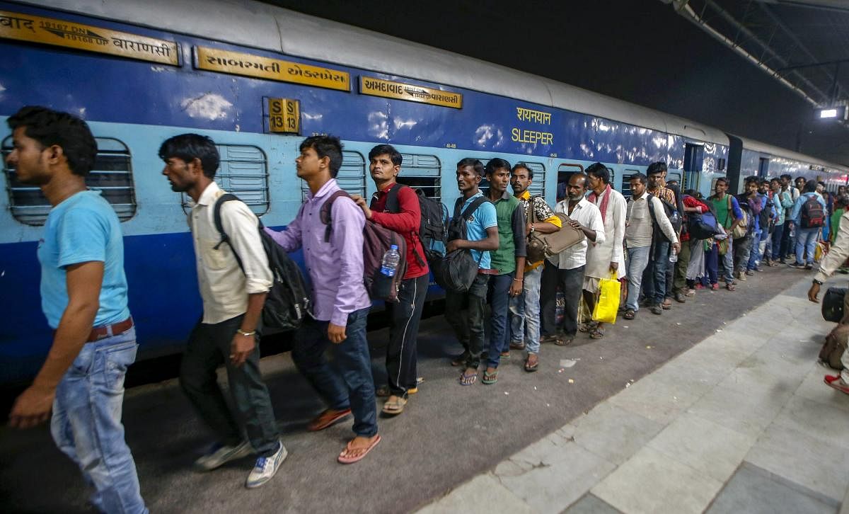 Migrant workers prepare to board the Sabarmati Express in view of protests which broke out over an alleged rape of a 14-month-old girl, in Ahmedabad, Monday, October 8, 2018. (PTI Photo)