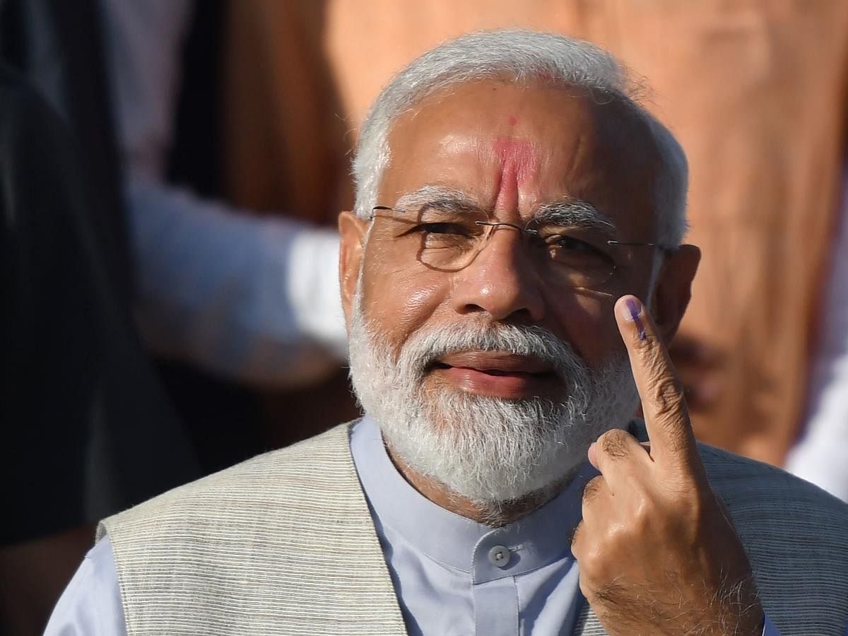 Prime Minister Narendra Modi displays his ink-marked finger after casting his vote during the third phase of general elections at a polling station in Ahmedabad. AFP photo