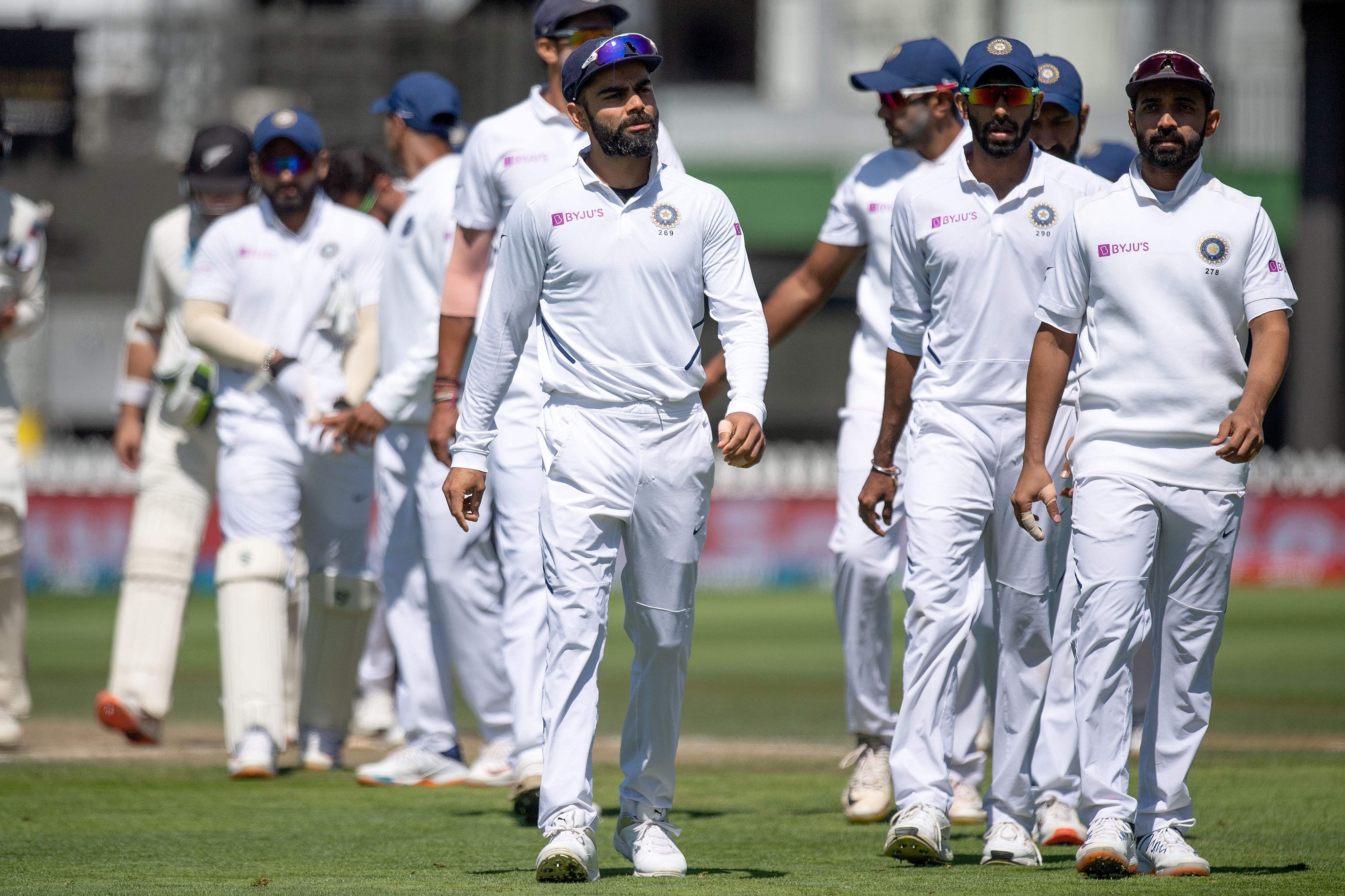 India's captain Virat Kohli (C) walks from the field with his team after losing the match to New Zealand during day four of the first Test cricket match between New Zealand and India at the Basin Reserve in Wellington. (AFP Photo)