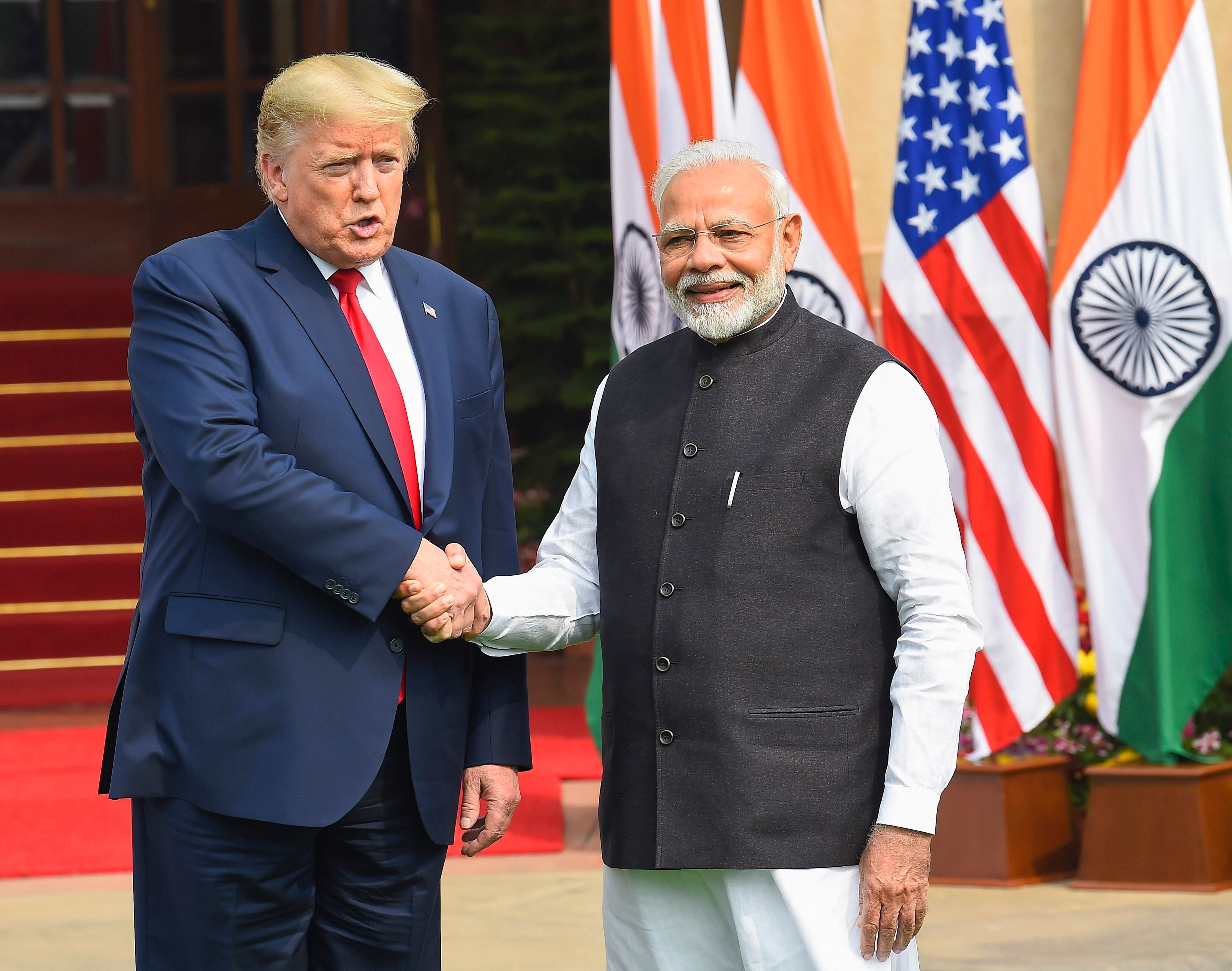 Prime Minister Narendra Modi shakes hands with US President Donald Trump prior to their meeting at Hyderabad House. (Credit: PTI Photo)